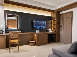 a living room with a tv on a wall at Wangkaew Hotel, Phitsanulok in Phitsanulok