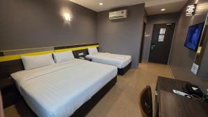 a hotel room with two beds and a desk at Kampar Boutique Hotel in Kampar