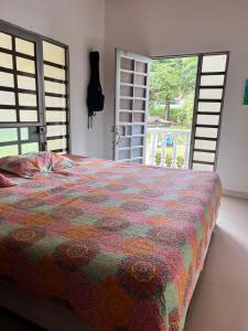 a bedroom with a bed with a colorful comforter at San Gerónimo Casa Hostal in Mocoa