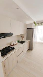 a kitchen with white cabinets and a stove top oven at Green Oasis - Dominicus, Bayahibe in La Laguna