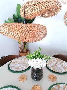 a table with plates and a vase of flowers on it at Green Oasis - Dominicus, Bayahibe in La Laguna