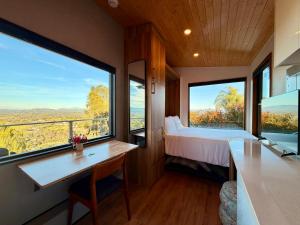 a bedroom with a bed and two large windows at Hilltop View Sanctuary in Fallbrook +56 photos