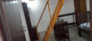a ladder leading to a room with a bed and a television at Eco Palms in Pottuvil