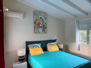 a bedroom with a blue bed and a picture on the wall at Chez Francis in Petit-Bourg +72 photos