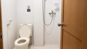 a bathroom with a shower with a toilet and a door at Nakula Familiar Inn in Denpasar