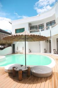 a swimming pool with an umbrella next to a house at bassa resort in Panglao Island