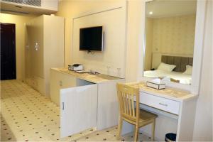 a room with a desk and a bedroom with a bed at Basra Touristic Hotel in Al Başrah