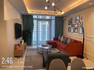a living room with red couches and a tv at Arabian Prime in Dubai