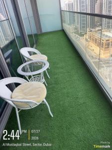 a balcony with two chairs and green carpet at Arabian Prime in Dubai