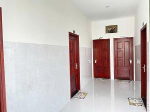 three doors in a room with white walls at Khách sạn Thành Châu 3 in Ấp Mỹ Hòa