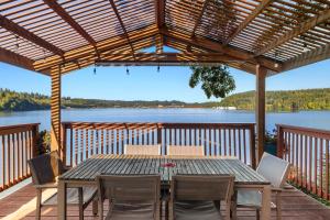 a table on a deck with a view of a lake at Phenomenal Sunsets Wild Orca & Private Beach in Shelton