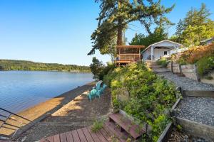 a house on the shore of a body of water at Phenomenal Sunsets Wild Orca & Private Beach in Shelton