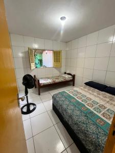a small room with two beds and a window at Surf e Café in Cabo de Santo Agostinho +3 photos