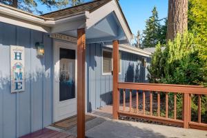 a small blue house with a porch and a door at Phenomenal Sunsets Wild Orca & Private Beach in Shelton