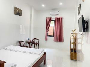 a room with a bed and a tv and a table at Khách sạn Thành Châu 3 in Ấp Mỹ Hòa