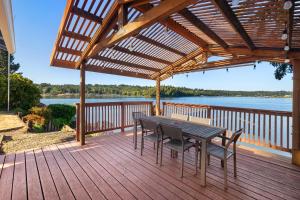 a wooden deck with a table and chairs on it at Phenomenal Sunsets Wild Orca & Private Beach in Shelton +45 photos