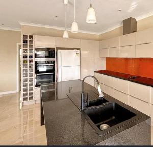 a kitchen with a sink and a black counter top at Your gateway to the Lakes in Bairnsdale +2 photos