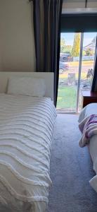 a bedroom with a white bed with a window at Your gateway to the Lakes in Bairnsdale