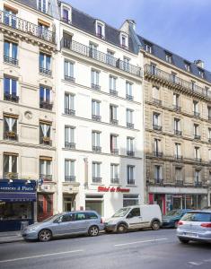 a large white building with cars parked in front of it at Hôtel de France Quartier Latin in Paris