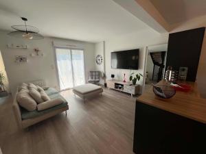 a living room with a couch and a flat screen tv at La Petite Citadine Proche Futuroscope in Poitiers