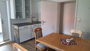 a kitchen with a wooden table with chairs and a table and a table at Am Fuße des Zoller in Bisingen