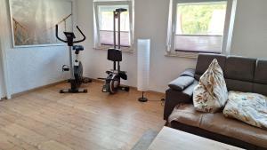 a living room with a couch and exercise equipment at Am Fuße des Zoller in Bisingen +5 photos