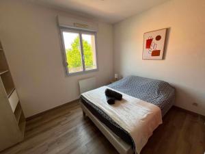a bedroom with a bed and a window at La Petite Citadine Proche Futuroscope in Poitiers +1 photo