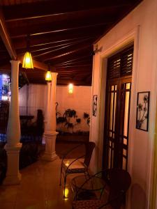 a porch with two chairs and a table and lights at White House Ella in Ella