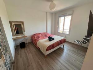 a bedroom with a bed and a mirror and a chair at La Petite Citadine Proche Futuroscope in Poitiers