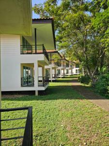 a large white building with a grass yard at Kaengkrachan Diamond Green Resort in Ban Song Phi Nong
