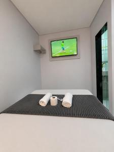 a bedroom with a bed with a tv on the wall at Hotel Colonial Plaza - Ao Lado do Metrô Armênia, 5 Min do Brás e Rua 25 de Março e 10 Min do Expo Pavilhões Anhembi in São Paulo