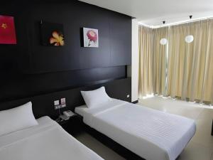 two beds in a bedroom with black walls at U Style Hotel in Ban Phang Khwang Tai