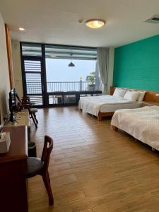 a hotel room with two beds and a balcony at 傳說民宿 Legend in Fenqihu
