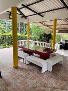 a table and benches on a patio at San Gerónimo Casa Hostal in Mocoa
