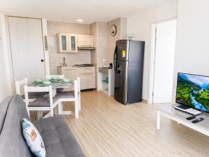 a living room with a couch and a kitchen with a refrigerator at Getaway at Fragata Style with Ocean View in Cartagena de Indias