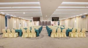 a banquet hall with blue and yellow tables and chairs at Guangna Hotel in Huizhou