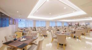 a restaurant with tables and chairs in a room at Guangna Hotel in Huizhou