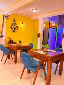 a dining room with two wooden tables and blue chairs at White House Ella in Ella
