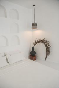 a white bedroom with a bed and a potted plant at bassa resort in Panglao Island