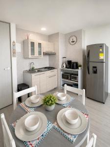 a kitchen with a table with chairs and a refrigerator at Getaway at Fragata Style with Ocean View in Cartagena de Indias