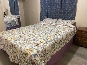 a bed with a floral comforter in a bedroom at Cozy Anchorage retreat in Anchorage