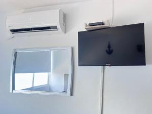 a tv and a mirror on a wall at Getaway at Fragata Style with Ocean View in Cartagena de Indias
