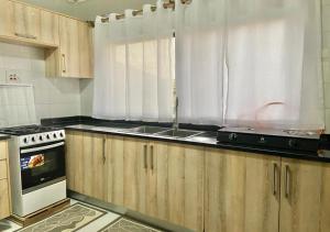 a kitchen with wooden cabinets and a stove top oven at Pizzaro Flats 2 in Chongwe +3 photos