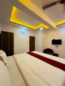 a bedroom with a large bed and a flat screen tv at Sevrina Beach Inn Calangute in Calangute +25 photos