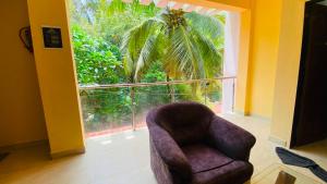 a chair in a room with a large window at Sevrina Beach Inn Calangute in Calangute