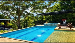 a swimming pool in a yard with a patio and trees at Finca Cabañas el Higueron in Nocaima