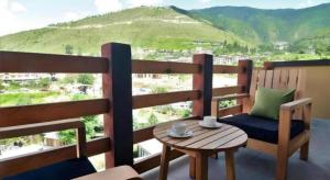 a chair and a table on a balcony with a view at Hotel Valley Thimphu in Tshalunang