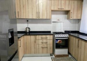 a kitchen with wooden cabinets and a stove at Pizzaro Flats 2 in Chongwe
