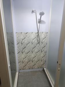 a shower in a bathroom with a stone wall at River cliff guest house in Gunungsriti