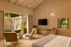 a bedroom with a bed and a tv and a table at Hidden Secrets Dambulla in Dambulla